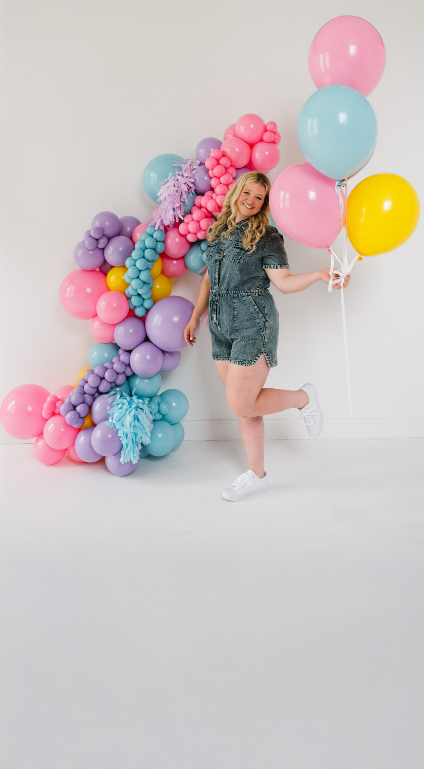 balloon artist brand shoot woman holding pastel balloons in studio kuballoons