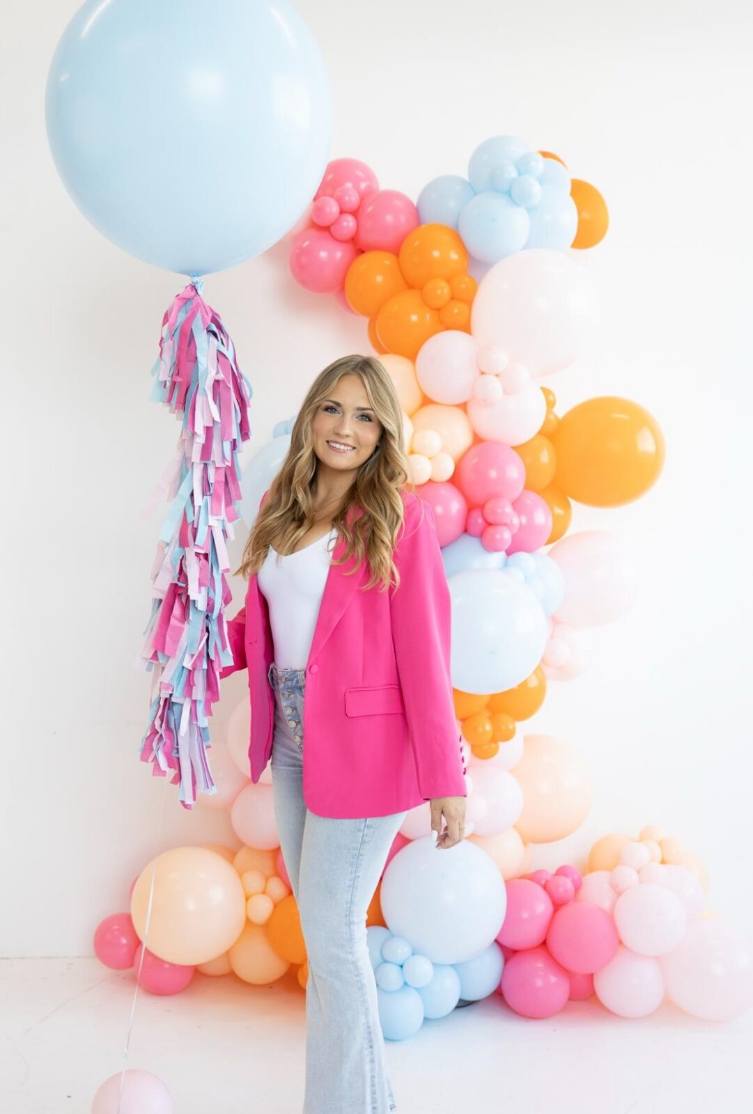 Balloon artist standing beside a colorful balloon garland, the kind of photo that supports balloon business SEO on a services page