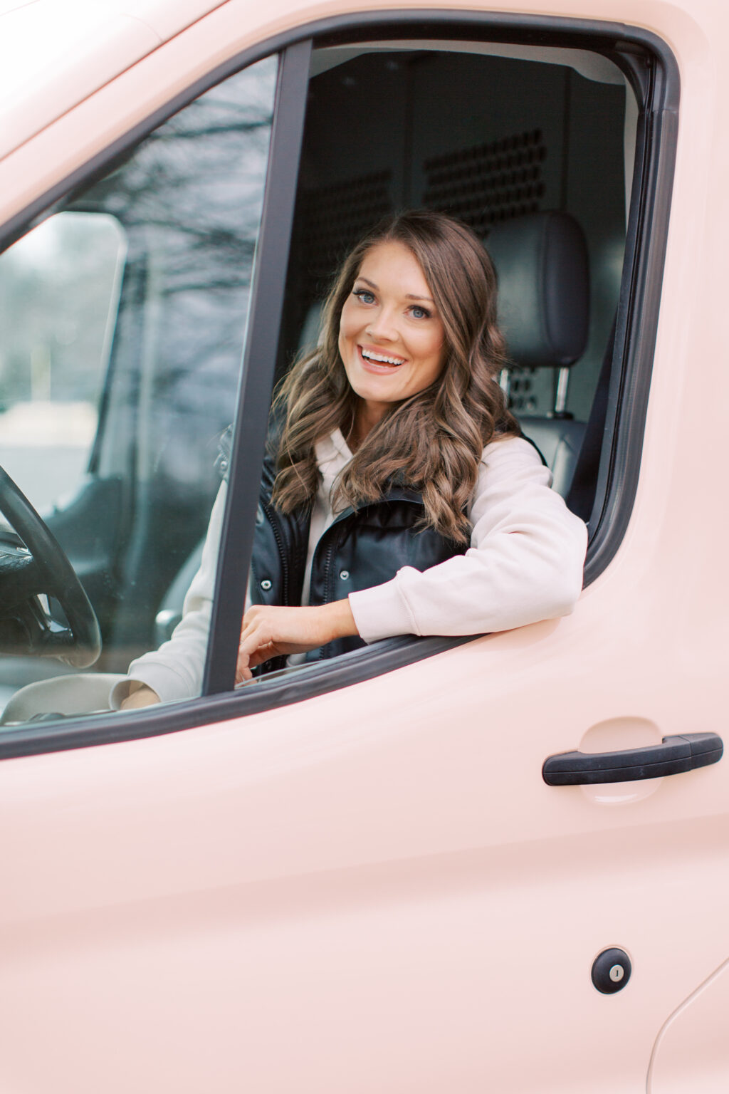 The Posh Balloon owner smiling from the window of her branded pink van