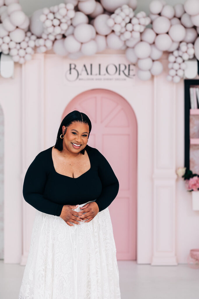 Lauren, founder of Balloré, in front of her pink storefront balloon installation