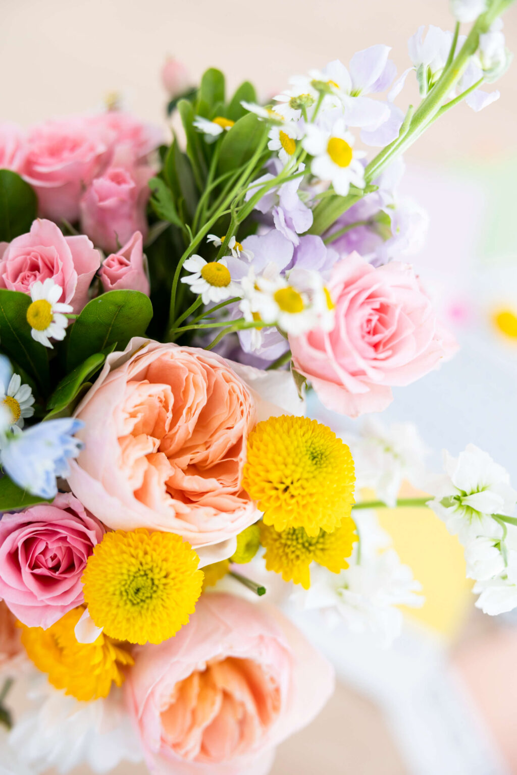 Pink, peach and yellow floral arrangement styled for a balloon business brand shoot